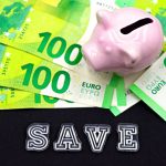 Tirelire posée sur des billets en euros illustrant l'épargne entre assurance vie et PER