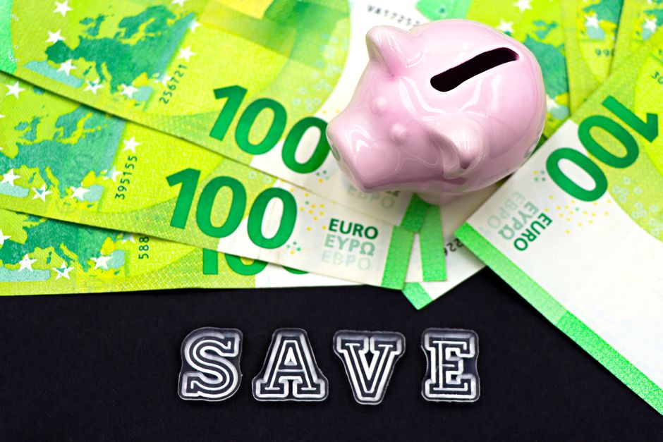 Tirelire posée sur des billets en euros illustrant l'épargne entre assurance vie et PER