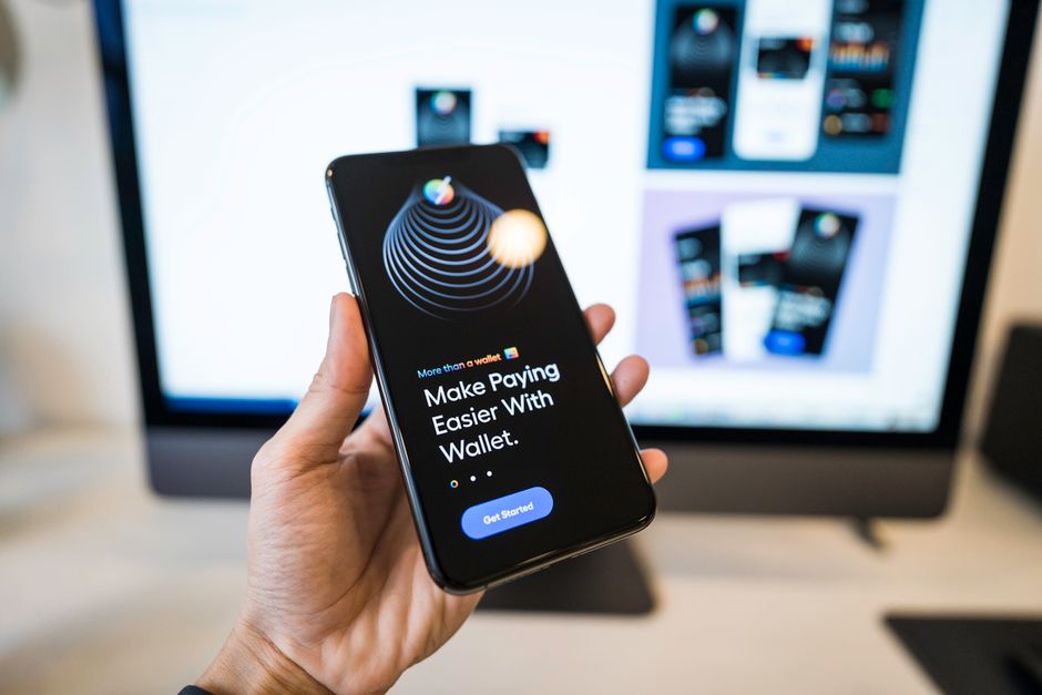 Main tenant un smartphone avec une application de portefeuille numérique bancaire