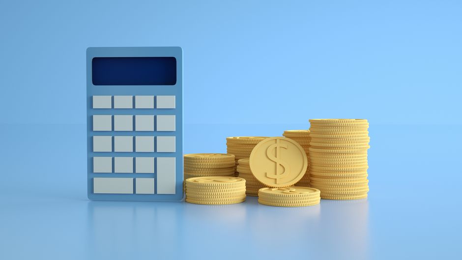 Calculatrice bleue et piles de pièces dorées pour calculer le rendement d'une épargne