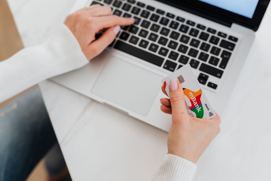 Personne utilisant un ordinateur portable avec une carte bancaire en main pour gérer un compte en ligne