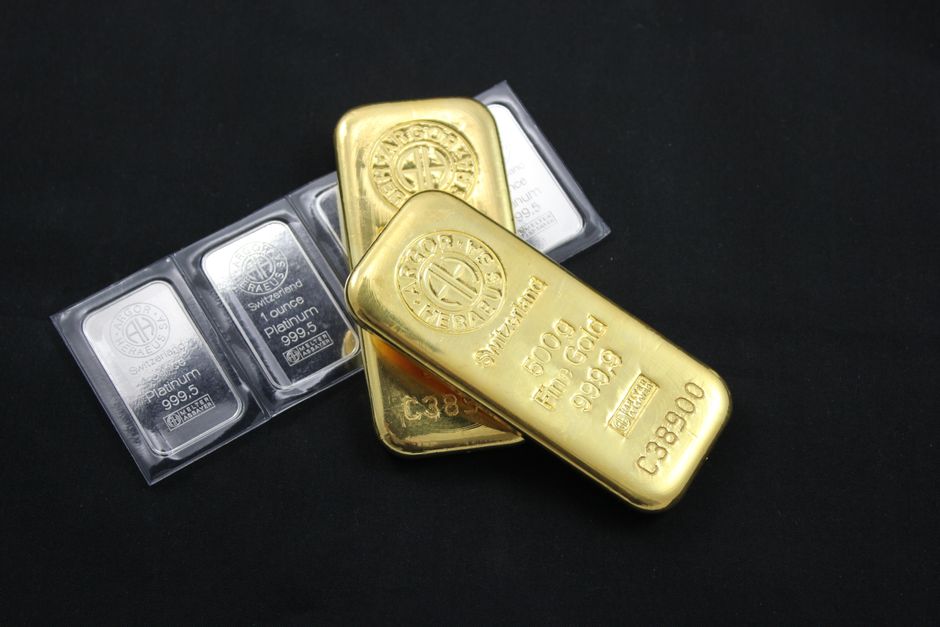 Deux lingots d'or posés sur des lingotins de platine sur fond noir