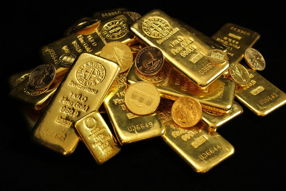 Tas de lingots et de pièces d'or sur fond noir