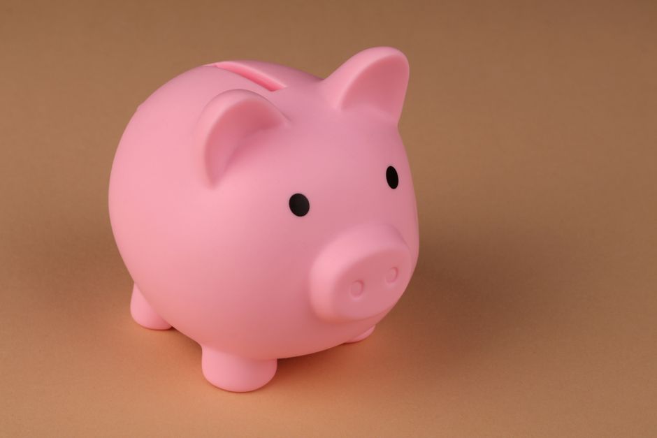 Tirelire cochon rose posée sur un fond beige, symbole de l'épargne et du placement sécurisé
